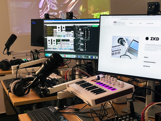 ZKD-Labor Drei Workstations mit digitalen Audiogeräten vor einer Videoprojektion im neuen ZKD-Labor